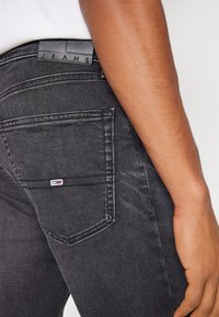 Tommy Jeans SCANTON SLIM - Prigludę džinsai - denim black