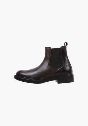 Bota Chelsea de cuero marrón con paneles laterales elásticos, puntera redonda, tirador y una gruesa suela de goma negra. Superficie plana y texturizada.