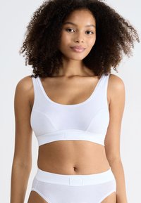 Witte katoenen bralette met brede bandjes, een gladde textuur en een band met een klein logo aan de voorkant. Gecombineerd met bijpassende witte slipjes.