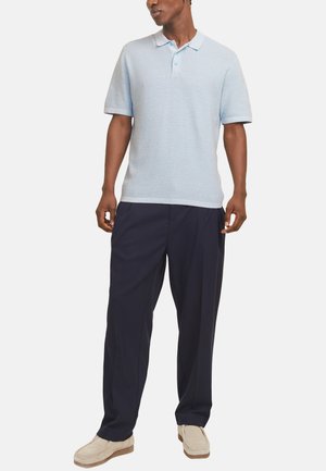 Lyseblå kortærmet polo skjorte med tekstureret stof, tre-knaps lukning og navy bukser; suppleret med beige loafers.