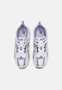 Vita och lavendelfärgade sportskor med meshpaneler och snören, med en framträdande 'N' logotyp och varumärkning på innersulan.