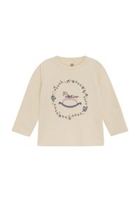 Crème-kleurig shirt met lange mouwen, voorzien van een schommelpaard grafiek omringd door bloemenpatronen in verschillende kleuren, gemaakt van zachte stof.