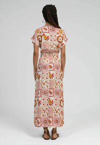 Robe maxi en tissu léger, ornée d'un motif floral rouge, orange et jaune sur un fond crème ; taille élastique et manches courtes.