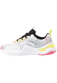 Weißer Sportschuh mit einem atmungsaktiven Mesh-Obermaterial, schwarzen Akzenten, gelben und pinken Highlights sowie einer klobigen weißen Sohle. Verfügt über Schnürsenkel und ein Logo.
