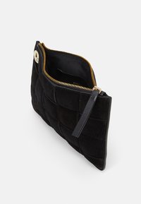 Černá semišová kabelka s tkaným vzorem, se zlatým zipem a koženým akcentem. Otevřený pohled ukazuje vnitřní podšívku.