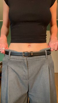 Szare spódnice plisowane z szerokim paskiem w talii oraz czarnym skórzanym paskiem. Pasek ma metalową klamrę i jest nieco luźny w talii.