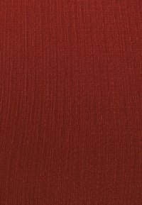Tessuto testurizzato di un profondo colore rosso, con un motivo a coste orizzontali che aggiunge dimensione e interesse visivo.