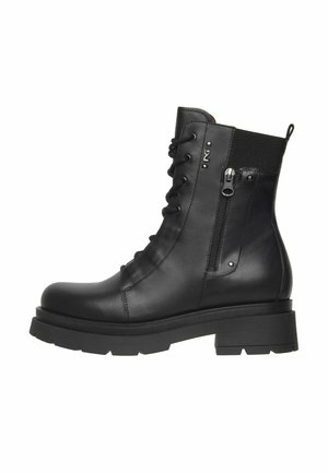 Stivaletto in pelle nera con zip laterale, frontale con lacci, suola spessa, pannello elastico sul retro e una piccola linguetta di estrazione.