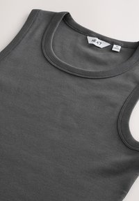 Débardeur gris côtelé avec un col rond, doté d'une finition soignée et de l'étiquette de la marque "NEXT" à l'intérieur du col. Étiquette de taille visible.