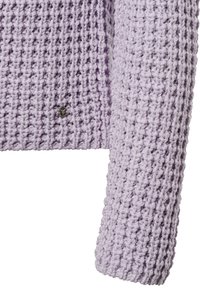 Lila gestrickter Pullover mit strukturiertem Muster, lockerem Geflecht und einem kleinen silbernen Logoakzent an der Seite. Die Ärmel reichen bis zur Mitte des Unterarms.