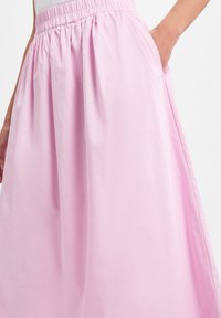 Helle rosa Midi-Rock aus glattem Stoff, mit einem elastischen Bund und Seitentaschen, in einem voluminösen, fließenden Design.