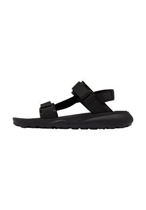 Sandalias negras con tiras ajustables, suela de goma texturizada y diseño minimalista. Las tiras están hechas de material sintético duradero.