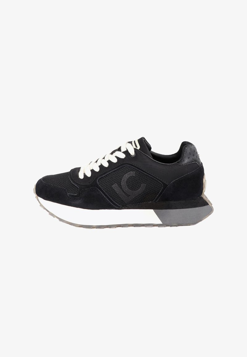 Baskets de sport noires avec lacets blancs, panneaux en mesh et en suède, marquées "IC" sur le côté, avec semelle blanche et grise sur fond blanc.