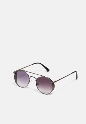 Ochelari de soare rotunzi cu lentile gradient violet, ramă metalică subțire, accente texturate pe părțile laterale și vârfuri din plastic negru pe brațe.