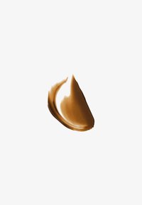 Bande lissée de crème marron moyen ou produit cosmétique sur un fond blanc uni.