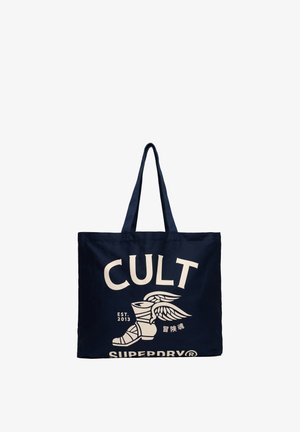 Granatowa torba na ramię z długimi uchwytami, biały tekst "CULT", grafika ze skrzydlatym butem oraz oznaczenia "Est. 2013" i "Superdry".