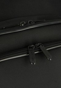Black textured nylon bag featuring dual black zipper pulls with the brand name "DERMATA" embossed on them.