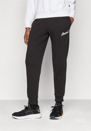Pantalones de chándal negros hechos de una tela suave, con un diseño ajustado y puños elásticos. Los pantalones tienen un logo blanco de Puma en el muslo izquierdo.