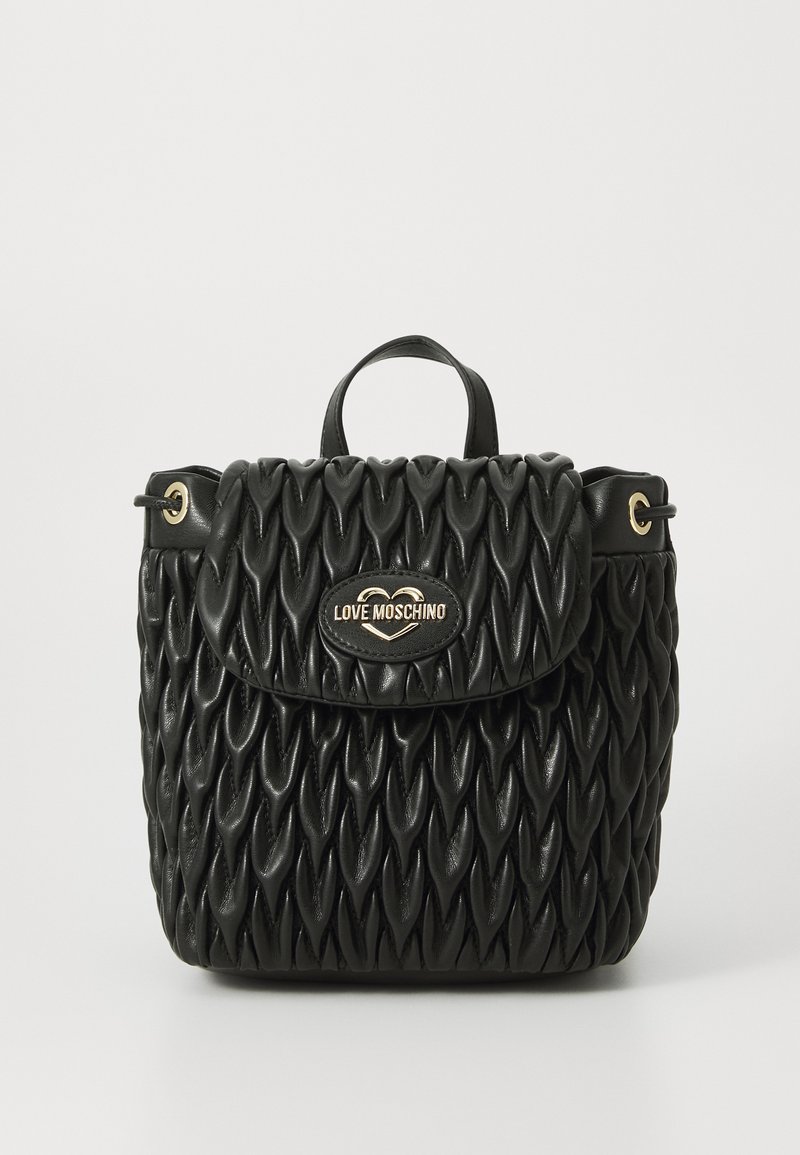 Schwarze gesteppte Handtasche mit strukturiertem Design, ausgestattet mit einem oberen Griff, goldenen Beschlägen und einem Logo-Schild auf der Vorderseite. Texturierte Oberfläche.