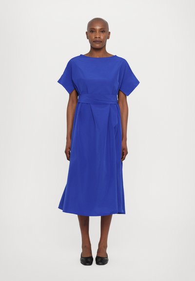 Robe midi bleue à manches courtes, avec une ceinture nouée à la taille et une jupe fluide. Fabriquée à partir d'un tissu doux avec une texture minimale.