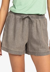 Šedé, lehké šortky s elastickým pasem a šňůrkou na stažení. Mají uvolněný střih a ohrnutý lem. Měkká textura a ležérní design.