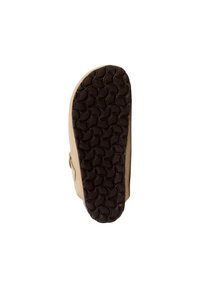 Suela de goma marrón con un patrón ondulado texturizado. Material superior en tono beige con una ligera curvatura en la punta. Presenta un perfil plano y sin acentos visibles.