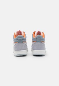 Sneakers alte in suede grigio e bianco con dettagli arancioni. Presentano un collare imbottito, materiale testurizzato e un dettaglio del logo sul tallone.