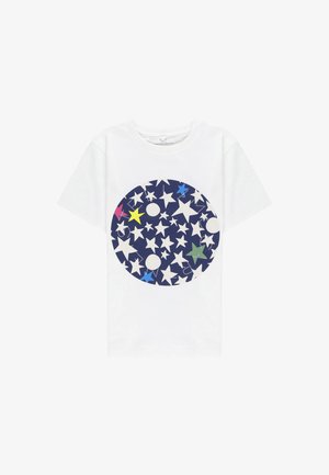 T-shirt in cotone bianco con un grafico circolare blu navy che presenta stelle e pallini bianchi e colorati, mostrando vari colori e design vivaci.
