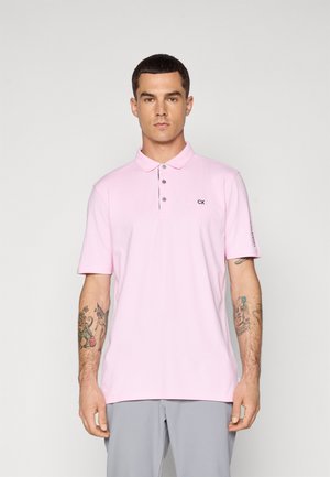 Ljust rosa polo skjorta gjord av slät tyg, med krage, tre-knappskniv och en liten svart logotyp på bröstet.