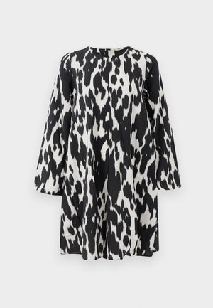 Čierno-biele šaty s odvážnym leopardím vzorom, s dlhými rukávmi a rovnou siluetou, vyrobené z textúrovaného materiálu.