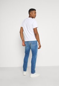 Tommy Jeans AUSTIN SLIM TAPERED - Calças de ganga justas - light blue denim