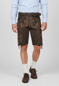 Brown leather shorts with decorative stitching, red accents, and side buttons. Worn with a light blue shirt and brown shoes.