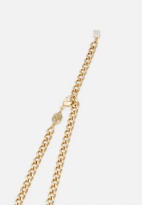Gouden armband met in elkaar grijpende schakels, voorzien van een duidelijke edelsteenaccent en een kreeftsluiting. Inclusief een ronde logo-tag.