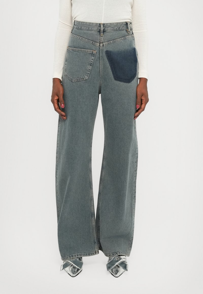 Wide-leg denim jeans in light gray with a contrasting dark blue pocket. Features a high waist, frayed hems, and classic five-pocket styling.