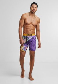 Fialové boxerky s potlačou peňazí, s žltým pásom. Vyrobené z elastického materiálu, s dĺžkou po kolená a čiernymi akcentmi.