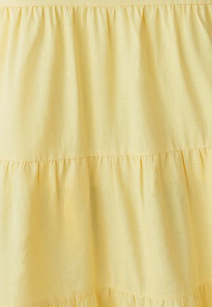 Kollane kihiline kangas pehme tekstuuriga, millel on horisontaalsed voldid ja sile pind. Värv on ere ja ühtlane üle kogu pind.