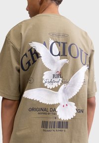 Olive green cotton t-shirt featuring a large graphic of two white doves with pink accents on the back, and text in dark blue.