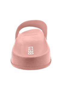 Sandale glissante de couleur rose clair avec une surface lisse et mate, une sangle arrondie et une semelle plate. Présente un logo de marque blanc sur le dessus.