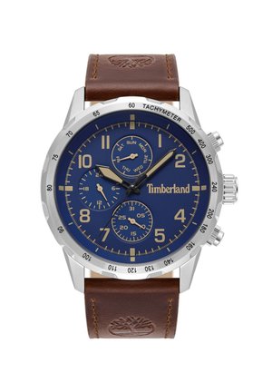 Zegarek Timberland z niebieską tarczą, srebrną stalową obudową i brązowym skórzanym paskiem. Posiada subtarczy chronografu oraz tachymetr.