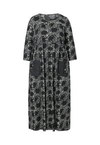 Vestido maxi a rayas en blanco y negro con mangas tres cuartos, escote redondo y dos bolsillos laterales con detalles texturizados.