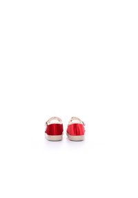 Zapatos de satén rojo con correa trasera y suelas texturizadas en blanco. Forrados con una tela de patrón de estrellas, con un detalle de hebilla metálica.