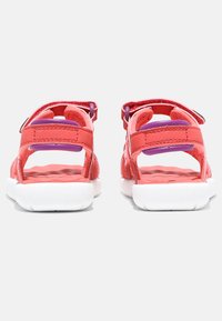 Rosa sandaler med justerbara remmar, vita sulor och en texturerad innersula. Har en lila detalj på remmen för extra stil.