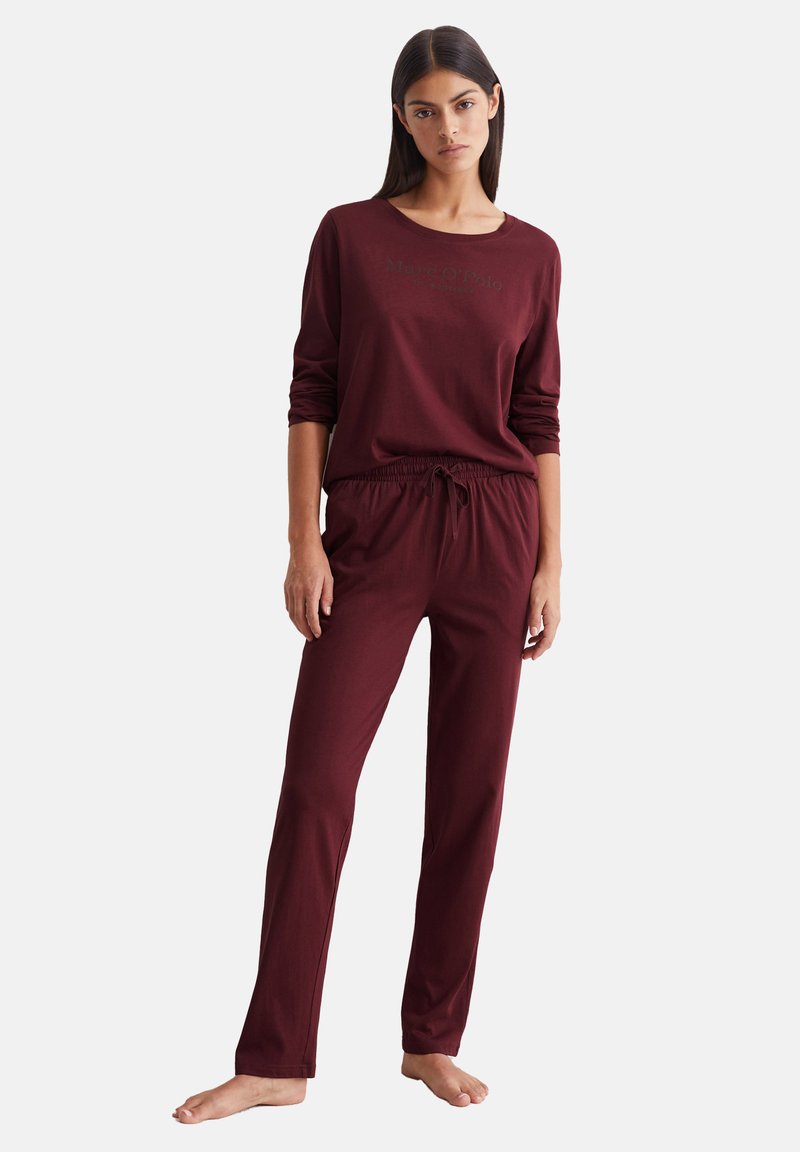 Bordeauxfarbenes Lounge-Wear-Set mit langen Ärmeln und elastischem Bund. Glatte Textur und lockere Passform, mit einem dezenten Logo auf dem Shirt.