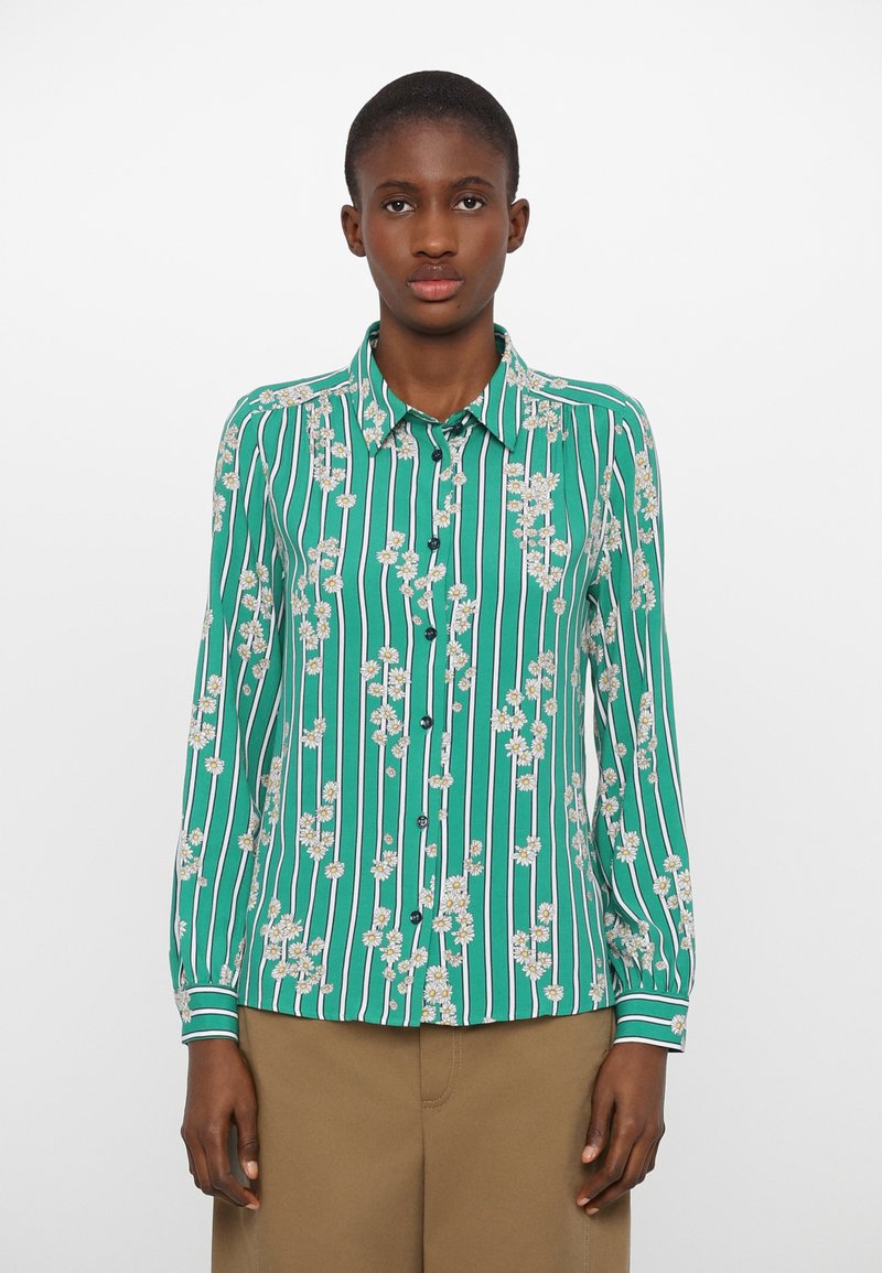 Green button-up shirt with vertical white stripes, featuring floral patterns in yellow and white. Long sleeves with buttoned cuffs.