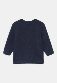 Mörkt marinblå, mjuktexturerad, långärmad tröja med rund halsringning och ribbade ärmslut och nederkant. Inga synliga mönster eller detaljer.