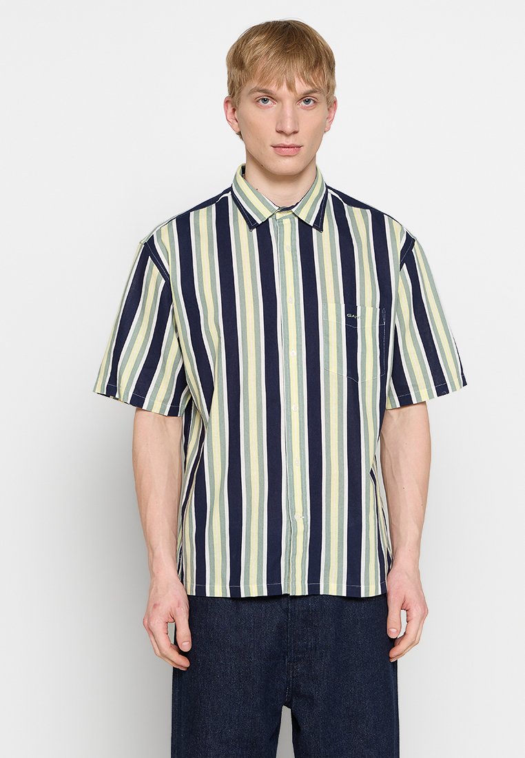 Kurzarmhemd mit vertikalen Streifen in Marineblau, Grün und Creme, mit knöpfbarem Kragen und einer Brusttasche. Hergestellt aus leichtem Stoff.