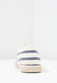 Leinenschuhe mit Marine- und weißen Streifen, ausgestattet mit einer Jutesohle, geschlossenem Fersenbereich und minimalistischem Design.