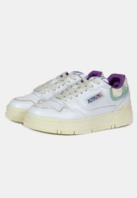 Sneakers bianchi in pelle con suole in gomma crema, dotati di lacci beige e accenti in viola, verde e blu sul tallone e sulla linguetta.