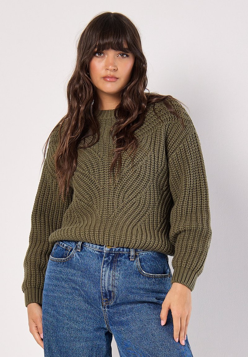 Olijfgroen gebreid sweater met een textuur van golven, ronde halslijn en wijde mouwen, gecombineerd met hoge taille blauwe jeans.