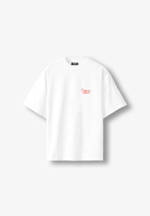 Balts T-krekls ar īsām piedurknēm un apaļu apkakli ar nelielu sarkanu kursīvu uzrakstu "Compare Bliss" kreisajā krūšu daļā.